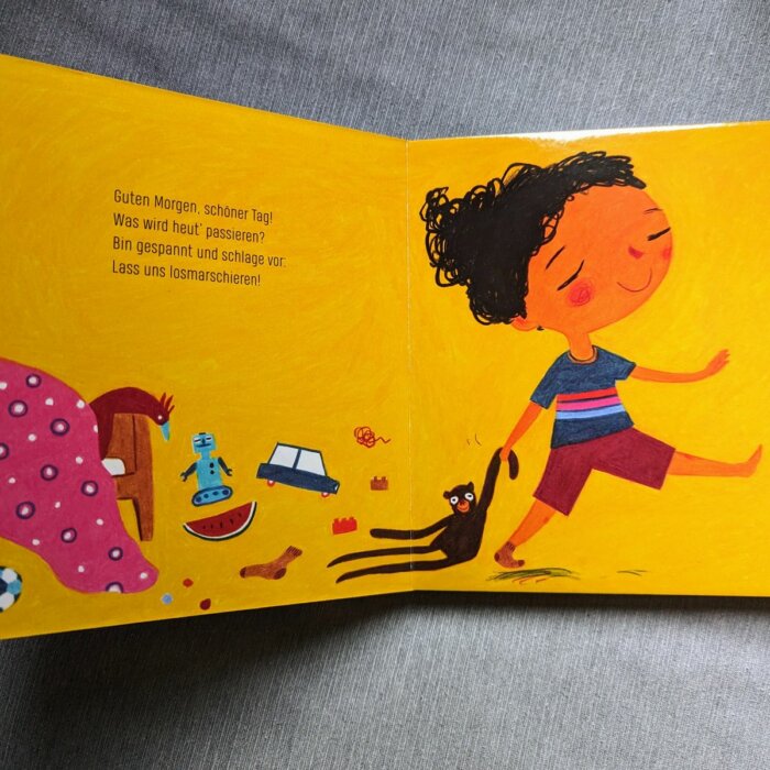Doppelseite aus dem Pappbilderbuch "Guten Morgen. schöner Tag". Ein Kind schnappt seinen Teddy und verlässt gutgelaunt das Kinderzimmer.